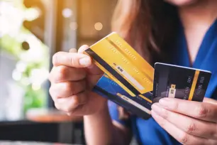 A person in debt holding multiple credit cards in hand