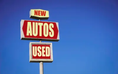 car dealership sign offering new and used cars